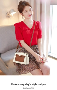 Close-up of a mini leather crossbody bag in cream and brown with metal buckle detail