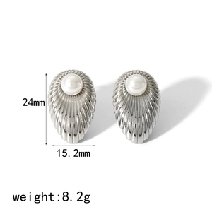 Macro detail of silver tear-drop earrings with white pearl and ribbed metal texture