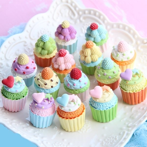 Macro view of fifteen colorful miniature resin cupcakes on a white relief plate