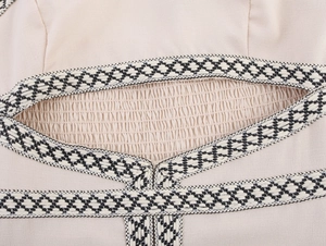 Dettaglio di un abito boho con nastro intrecciato geometrico e trama in tessuto a nido d'ape