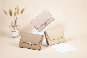 Detailed close-up of quilted PU leather wallets in beige and pink with leaf pendants
