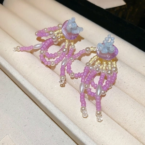 Detailed macro shot of colorful handmade beaded flower earrings with faux pearls and beads
