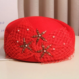 Detail of red wool beret featuring mesh veil and elegant pearl bead star decorations