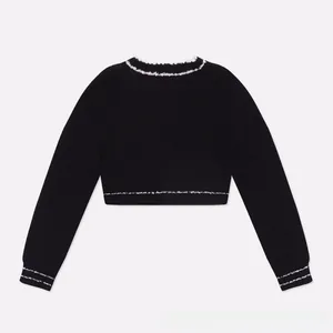 Back view of cropped black knit jacket featuring contrast white trim on collar and hem
