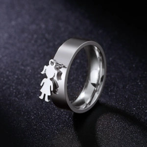 Macro shot of polished stainless steel ring with a delicate hanging girl pendant