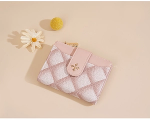 Detailed macro shot of pink and white quilted wallet with golden star buckle