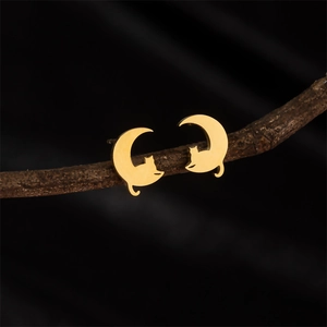Minimalist stainless steel cat on moon earrings in gold finish on wood branch