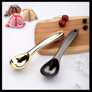Polished gold and dark gray self-thawing ice cream scoops on a white table background