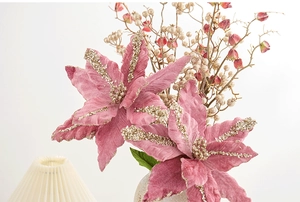 Détail de fleur de Noël rose avec pétales en velours et paillettes dorées brillantes