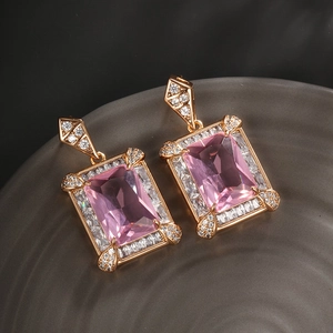 Macro detail of pink rectangular crystal earrings with zircon halo on a ceramic plate