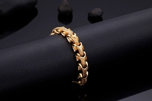 Gros plan du bracelet écailles de dragon doré sur support en cuir noir