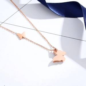 Minimalist 18K rose gold butterfly pendant necklace with double charm on cross chain