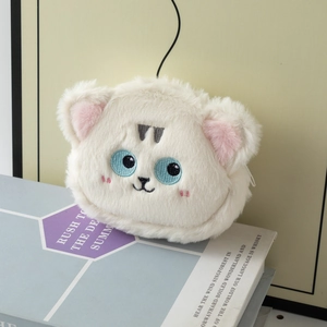 Dettaglio del portamonete in peluche bianco con occhi ricamati e consistenza morbida
