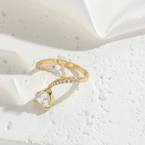 Detail of adjustable gold ring featuring two heart-shaped zircons and diamond accents
