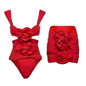 Detail of red swimsuit set with 3D floral accents and ruched textured fabric