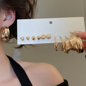Golden heart and hoop earring set displayed on a model and card for daily casual wear