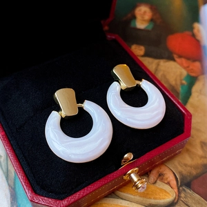 Detail of hollow round drop oil earrings in a luxury red jewelry box with velvet lining