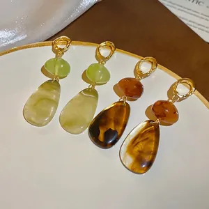 Elegant irregular resin geometric drop earrings in amber and emerald green with gold rings