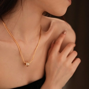 Gold plated layered necklace with sparkling zircon spherical pendant on a model