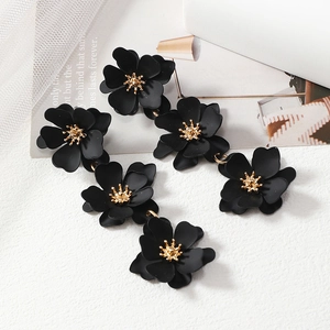 Elegant long black floral drop earrings with gold stamen and matte finish on white background