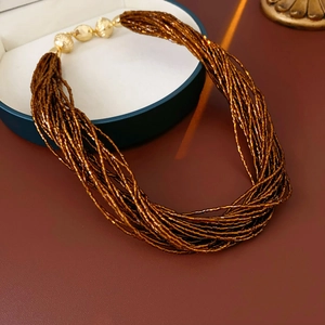 Dettaglio della collana a più fili di perle bronzo con perle dorate incise a mano