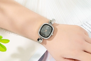 Elegant ladies' silver mesh watch with crystal bezel and dark grey sunburst dial on wrist