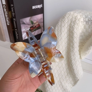 Detail of the butterfly acetate hair claw showing the durable spring and marble texture