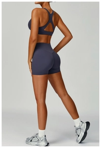 Detail view of high-waist fitness shorts and open back sports bra in purple gray