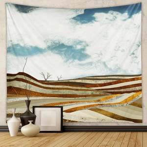 Detail of abstract landscape wall tapestry with layered golden hills and blue sky clouds