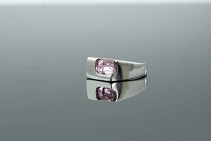 Macro shot of silver ring featuring a rectangular pink zircon stone in bezel setting