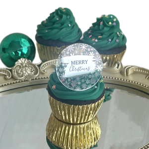 Macro detail of acrylic Christmas cupcake topper with Merry Christmas engraving and snowflakes