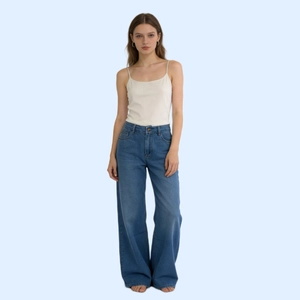 Dettaglio di jeans blu a vita alta abbinati a un top a canotta bianco in stile casual