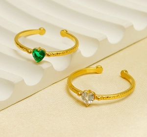 Detail of two heart-shaped gemstone open rings with gold hammered metal bands