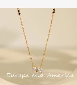 Detail view of gold necklace with round and water drop white zircon pendant on beige background