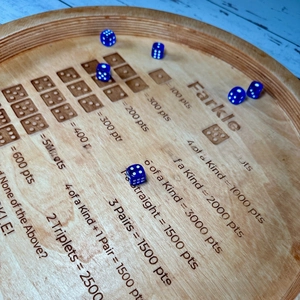 Macro shot of Farkle wooden dice tray with laser-engraved rules and blue dices
