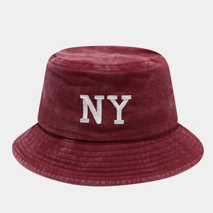 Detail of burgundy washed cotton bucket hat featuring white NY embroidered logo and texture