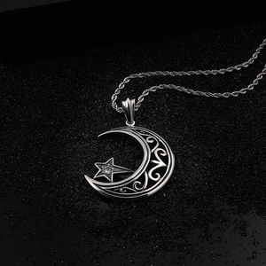 Vue détaillée du pendentif étoile et croissant de lune argenté avec détails en filigrane