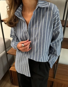 Gros plan détaillé de la chemise rayée bleue à manches longues avec boutons et col polo