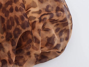 Close-up of leopard print fabric detail with sheer texture and soft drapery effect