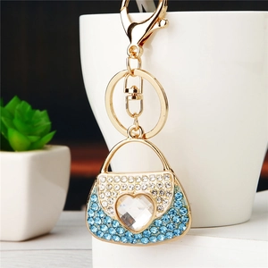 Detailed shot of golden handbag keychain with blue rhinestones and heart crystal