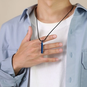 Detail view of blue rectangular tungsten pendant on a black cord necklace on a model