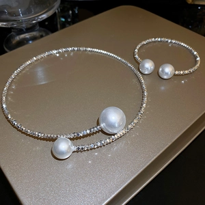 Detail of silver choker necklace and matching bracelet set with white faux pearls