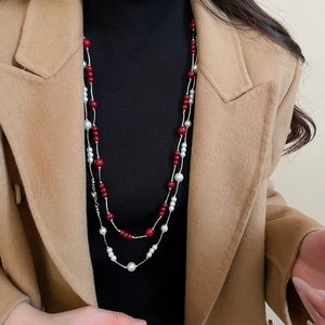 Detail view of double-layer long necklace with red beads and white imitation pearls