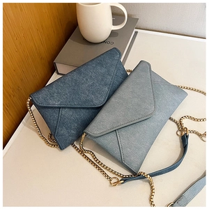 Detailed close-up of two envelope chain bags in dark and light blue denim texture