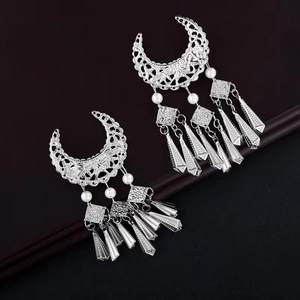 Détail d'une boucle d'oreille lune en argent avec perles blanches et longs pompons