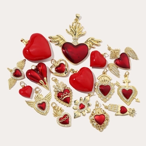 Collection of gold heart pendants with red enamel, featuring wings, crowns and sacred hearts