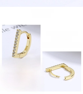Detailed macro view of S925 hallmark on gold-plated D-shaped earrings with zircons
