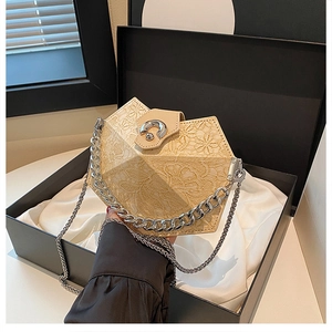 Detail of cream floral textured handbag with metal chain in a black gift box