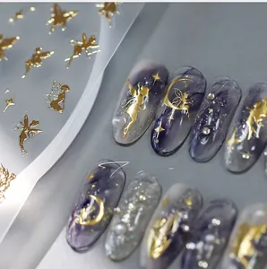 Detail showing golden fairy and crescent moon nail stickers on purple marble nails