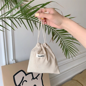 Detailed view of beige corduroy drawstring pouch with branded Sozakka woven label